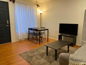 sala de estar con mesa y TV en Beach Gateway Full Kitchen 1 Bedroom Duplex, en Manhattan Beach