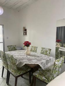 a dining room table with chairs and a vase with flowers at Cantinho do amor in Vitória