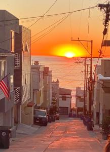 una calle de la ciudad con una puesta de sol en el fondo en Beach Gateway Full Kitchen 1 Bedroom Duplex, en Manhattan Beach