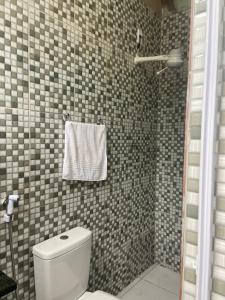a bathroom with a toilet and a shower with a towel at Cantinho do amor in Vitória +10 photos