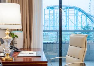 an office with a desk with a view of the roller coaster at 潍坊富华大酒店a座 in Weifang