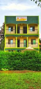een geel en groen gebouw bovenop een heuvel bij Lights of kazinga orphanage and homestay in Rubirizi