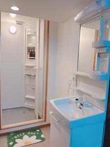 een kleine badkamer met een wastafel en een koelkast bij ひまわりHotel in Nagasaki