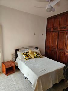 Un dormitorio con una cama con almohadas. en Condomínio Cabo Frio en Cabo Frío