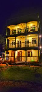 a large white building with balconies at night at Lights of kazinga orphanage and homestay in Rubirizi