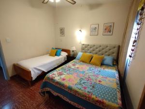 1 dormitorio con 2 camas y colcha. en Casa en Villa Carlos Paz solo apto para familias en Córdoba
