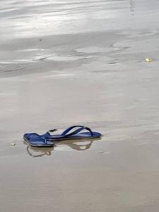 ein blauer Schuh auf dem Sand am Strand in der Unterkunft Casa de frente para o mar, pé na areia! in Rio do Fogo