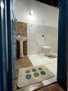 ein Badezimmer mit einem Waschbecken, einem WC und einem Teppich in der Unterkunft Casa de frente para o mar, pé na areia! in Rio do Fogo