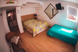 a small bedroom with a bed and a chair at Apart Hotel Sonoma in Viña del Mar