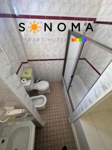 a bathroom with two toilets and a sign on the wall at Apart Hotel Sonoma in Viña del Mar