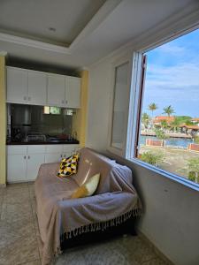 cocina con cama y ventana grande en Condomínio Cabo Frio en Cabo Frío