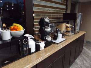 a kitchen counter with a microwave and a bowl of fruit at Magnuson Cedar City in Cedar City