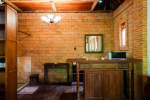 a bathroom with a sink and a brick wall at Harum Manis Cottages in Jepara