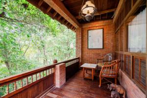 a porch of a cabin with a table and a chair at Harum Manis Cottages in Jepara