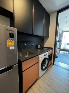 a kitchen with a sink and a washing machine at Condo Edge Central in Pattaya Central