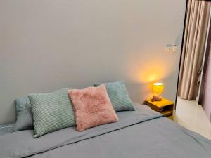 Una cama con una almohada rosa encima. en เคียงโขงพูลวิลล่าเชียงคาน Kiang Khong Pool Villa de Chiang Khan, en Chiang Khan