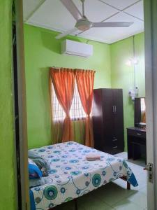 1 dormitorio con cama y ventana en Syukur Homestay Ipoh, en Ipoh