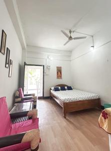 sala de estar con cama y sofá en Panchalaya Homestay, en Guwahati