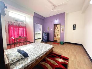 a bedroom with purple walls and a bed in a room at Panchalaya Homestay in Guwahati