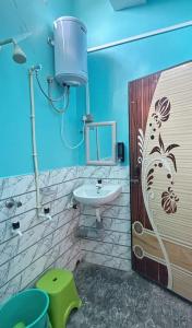 y baño con lavabo, aseo y espejo. en Panchalaya Homestay, en Guwahati