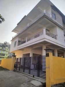 Biały dom z balkonem i bramą w obiekcie Panchalaya Homestay w mieście Guwahati