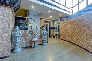 un pasillo con estatuas en la pared y una escalera en Collection O chamiers park, en Chennai