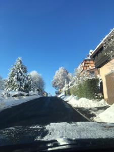 a snow covered road with trees and a house at Rhöner Sternenhimmel in Frankenheim