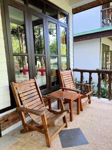 2 sillas de madera sentadas en el porche de una casa en Dream Valley Resort, Tonsai Beach en Tonsai Beach