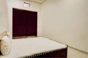 a bed in a room with a window at Spot On Chaudhary House in Hāthras