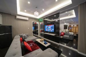 sala de estar con sofá blanco y TV en Luks Lofts Hotel & Residences en Batangas
