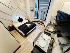 a bedroom with a bed and a table with a sink at Charm Central Studio in London