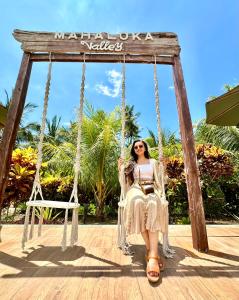 uma mulher sentada num baloiço num resort em Mahaloka Valley Nusa Penida em Nusa Penida