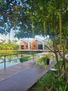 uma casa junto à água com mesas e árvores em November Garden ชัยนาท 