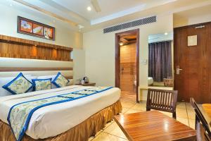 a bedroom with a large bed and a wooden table at Hotel Hari Piorko Grand - New Delhi Railway Station in New Delhi