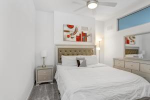 a white bedroom with a large bed and a window at Sunset Views from a Stylish 1BR High Rise in Tampa in Tampa
