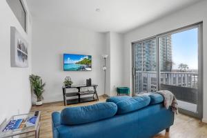 a living room with a blue couch and a large window at Sunset Views from a Stylish 1BR High Rise in Tampa in Tampa