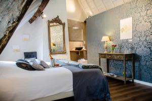 a bedroom with a bed with a mirror and a fireplace at The White Queen B&B in Bruges