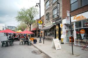 una calle de la ciudad con mesas, sillas y sombrillas en HRésidences Modern Condo on MAIN St Laurent Blvd, en Montreal