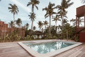 a pool in the backyard of a house with palm trees at ALON CLOUD9, beach front in Catangnan