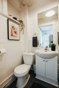 uma casa de banho branca com um WC e um lavatório em HRésidences Cozy Heritage St André Apt Mtl em Montreal