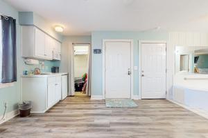 a kitchen with white cabinets and blue walls at Golf n' Sea B in Calabash
