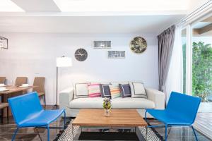 a living room with blue chairs and a couch at Reach Patong beach in one minute in Patong Beach