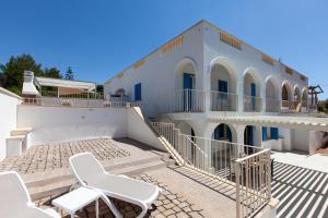 a white building with two chairs in front of it at La Primula Apartments in Salve