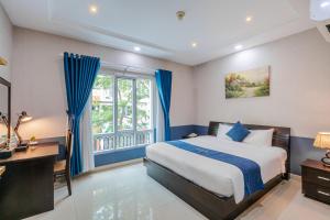 a bedroom with a bed and a desk and a window at La Serena Boutique Hotel in Ho Chi Minh City