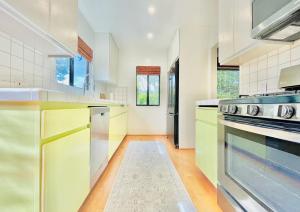 a kitchen with white walls and yellow cabinets at 2 BR 2 BA - Eco House and Garden Vacation Retreat and Remote Workspace for Families, Couples and Solo Travelers in Coveted Culver in Culver City