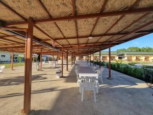 a wooden pavilion with white tables and white chairs at 34k Hotel and Resort powered by Cocotel 