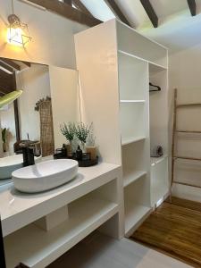 a white bathroom with a sink and a mirror at TukoKubo in El Nido