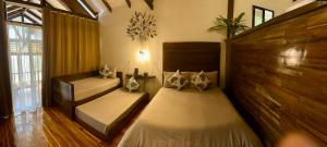 1 dormitorio con 2 camas y ventana en TukoKubo en El Nido