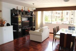 Hermoso departamento de dos dormitorios en el primer piso في ليما: غرفة معيشة مع كرسي أبيض وطاولة
