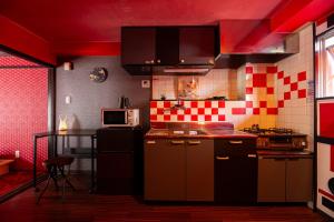 a kitchen with red walls and a red ceiling at Geisha Expelience Stay in Tokyo